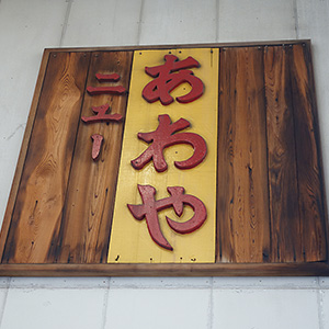 店主の兄が電動ノコギリで文字を彫って作った木製看板