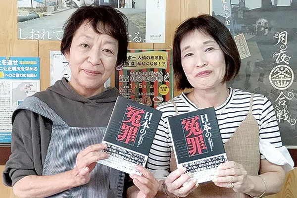 著書を手にする尾崎美代子さん(左)と、「ママは殺人犯じゃない ―冤罪・東住吉事件―」の著者、青木惠子さん=大阪市西成区の飲食店「集い処はな」