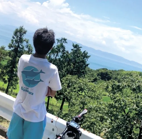 大自然の中で空を眺める小林さん