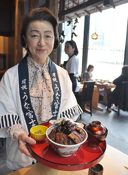「肝入上うなぎ丼」を配膳する同店大女将の岡田みさをさん
