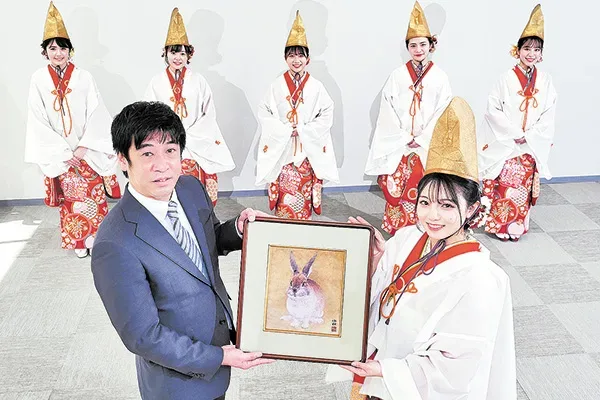 岡野総局長へ縁起物を手渡す福娘