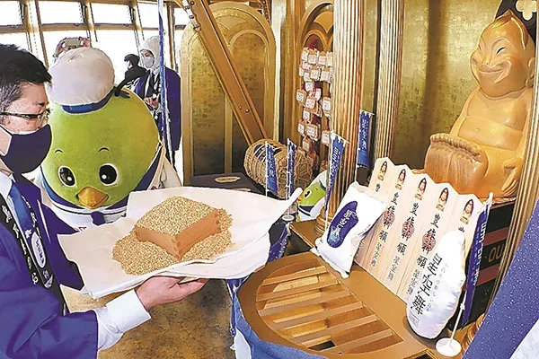 ビリケンさんに「星空舞」の豊作を祈願する松村所長＝13日、大阪市浪速区の通天閣