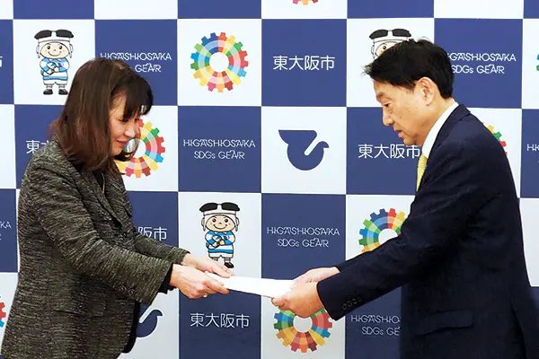 コロナワクチン接種後の対応に関する要望書を野田市長（右）に提出する三木さん＝2月25日、東大阪市役所